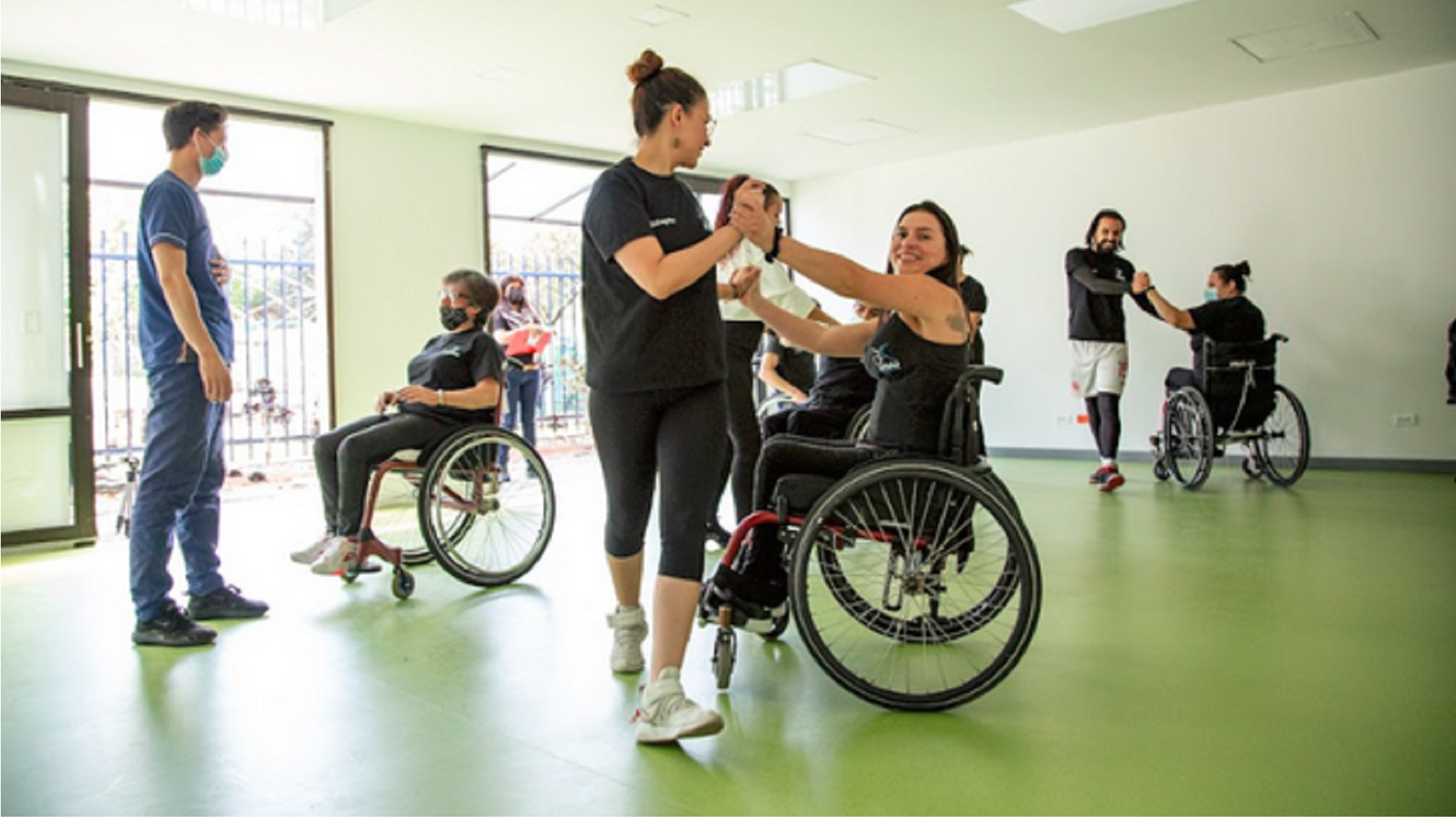 En la foto: Aura Lorena Varela, en silla de ruedas, bailando con una persona caminante.