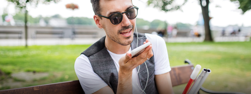 Persona con audífonos sostiene un celular en su mano derecha