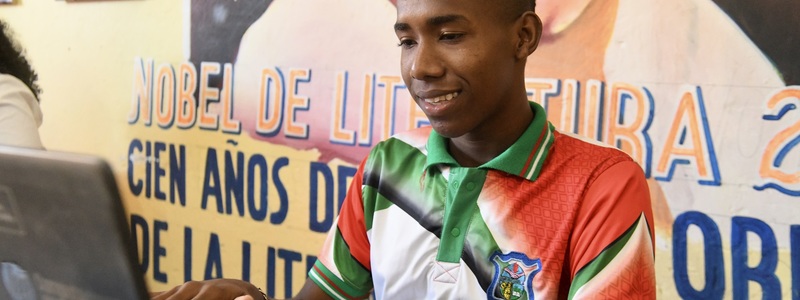 Un joven trabajando con un equipo portátil