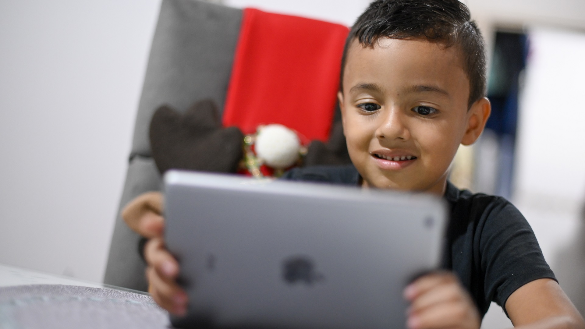 Niño interactúa con una tablet que tiene en sus manos