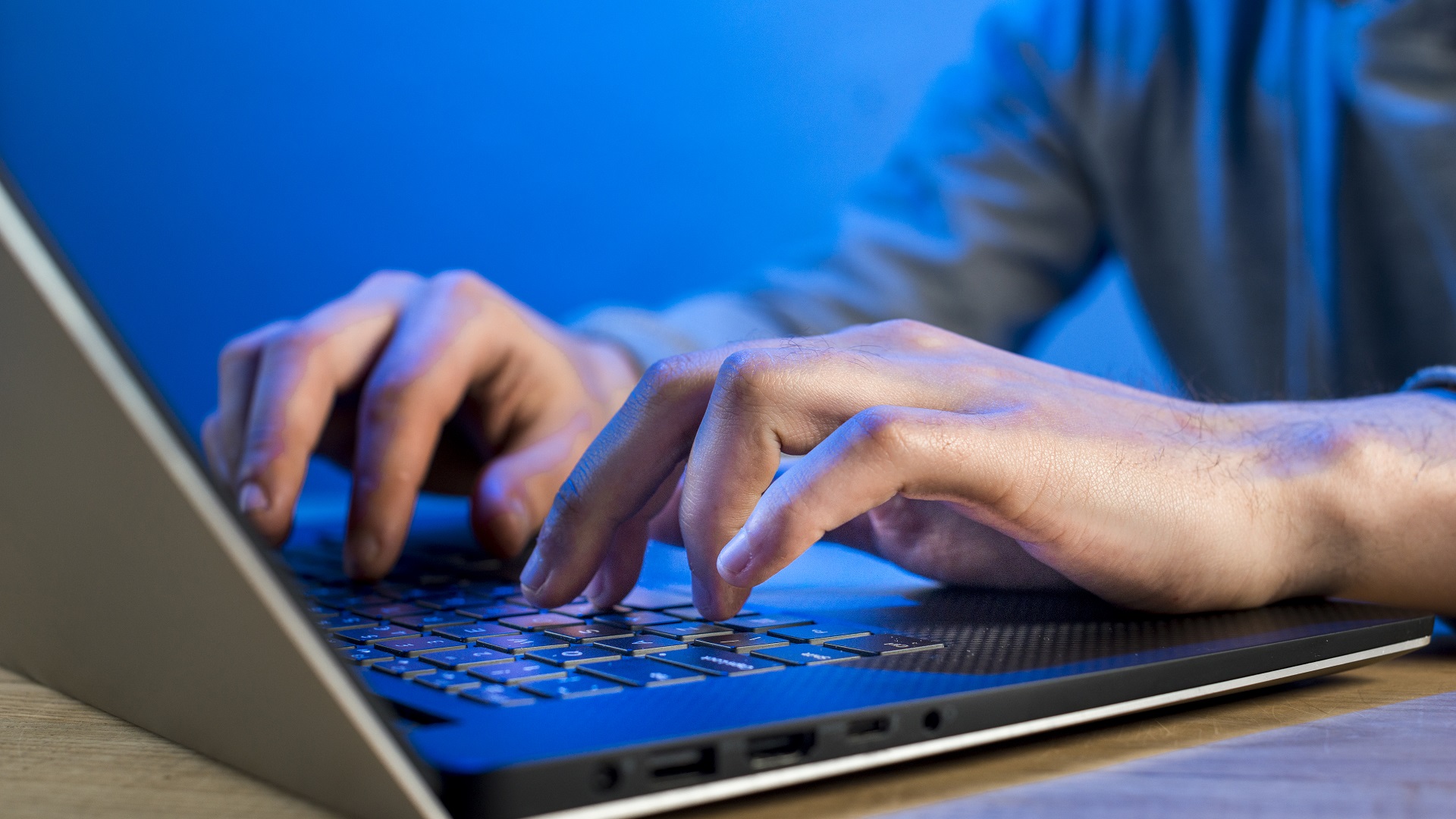 manos escribiendo en el teclado de un computador portátil