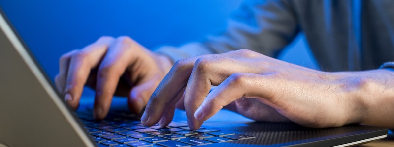 manos escribiendo en el teclado de un computador portátil
