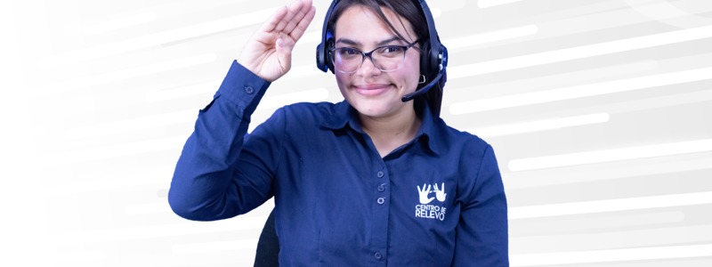 Una mujer sonriendo con la mano arriba